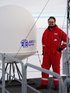 Alex (DL2ALY) neben der geschützten QO-100-Antenne auf dem Dach der Forschungsstation